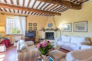 sala de estar con sofás blancos y chimenea en Il Giardino Inglese, en Lucignano