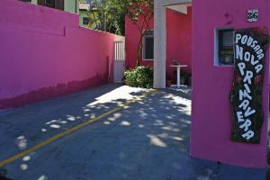a pink building with a sign on the side of it at Pousada Nova Primavera in Ubatuba