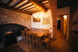 a wooden table and chairs in a room with a brick wall at Borgo 7 TigliAppartamento a Montepulciano n1 in Montepulciano