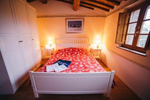 a bedroom with a bed with a red bedspread and two lamps at Borgo 7 TigliAppartamento a Montepulciano n2 in Montepulciano