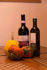 a bottle of wine and pumpkins on a table at Borgo 7 TigliAppartamento a Montepulciano n2 in Montepulciano