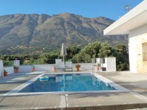 a swimming pool with a mountain in the background at Maria Place in Triopetra