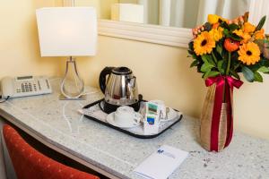 
a coffee pot sitting on top of a counter next to a vase at Capodichino International Hotel in Naples
