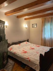 een slaapkamer met een bed met rode bloemen erop bij Casa Adelina in Valea Lungă-Cricov