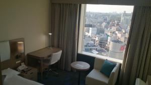 a hotel room with a window with a desk and a chair at Shibuya Excel Hotel Tokyu in Tokyo