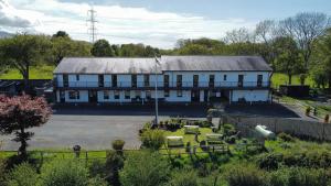 a large white building with a courtyard in front of it at Basecamp Wales in Llanllyfni