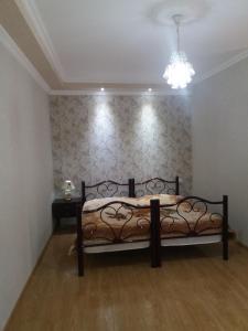 een slaapkamer met een bed en een kroonluchter bij Guest House Darejani in Koetaisi