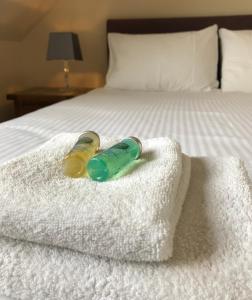 two bottles sitting on towels on a bed at Cornerstone in Mallaig