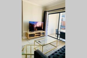 a living room with a couch and a television at Stay Upmarket at The Blyde in Boschkop