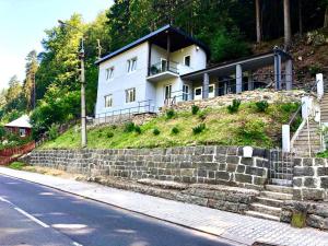 una casa en la cima de una colina con una pared de piedra en Holiday House Panda en Hřensko