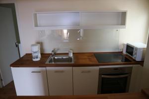 a small kitchen with a sink and a microwave at Sky Beach Can Picafort in Can Picafort