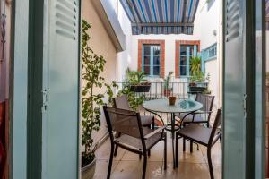 a patio with a table and chairs on a balcony at NOCNOC - Le Napoleon, 200m2 au cœur de Toulouse in Toulouse