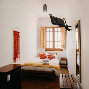 a bedroom with a bed with a tv on the wall at Maison verte - Guest House in Arequipa