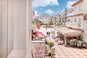 widok z balkonu ulicy ze stołami i krzesłami w obiekcie BHost - La Carihuela Los Perros w mieście Torremolinos