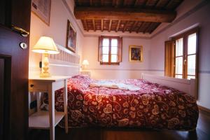 1 dormitorio con 1 cama y 1 mesa con lámpara en Borgo 7 TigliAppartamento a Montepulciano n5 en Montepulciano