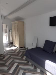 1 dormitorio con 1 cama y TV en la pared en Charmante petite maison à St Aygulf, en Saint-Aygulf