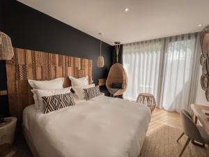 1 dormitorio con 1 cama grande con sábanas y almohadas blancas en Le Saint Remy en Saint-Rémy-de-Provence