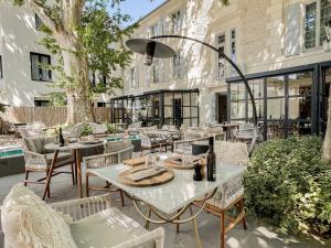 a patio with tables and chairs in front of a building at Le Saint Remy in Saint-Rémy-de-Provence