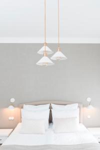 1 dormitorio con 2 camas, almohadas blancas y luces en Berchy Apartment 3, en Liepāja