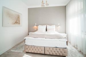 1 dormitorio con 1 cama grande y paredes blancas en Berchy Apartment 3, en Liepāja