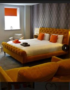 a bedroom with a large bed with orange pillows at Mansion Court in Doncaster