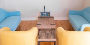 a living room with two blue couches and a coffee table at Quinta de Carcavelos Natures Home in Amarante