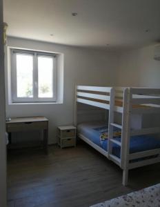 - une chambre avec des lits superposés, un bureau et une fenêtre dans l'établissement Casa Julie, à Patrimonio