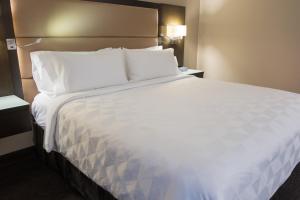 un grande letto bianco in una camera d'albergo di Holiday Inn Vancouver Downtown & Suites, an IHG Hotel a Vancouver