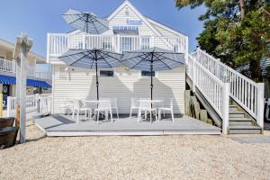 a patio with chairs and umbrellas in front of a house at Surf City Hotel in Surf City