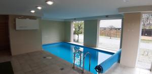 - une piscine avec un sol bleu dans un bâtiment dans l'établissement Riviéra Wellness Apartman, à Siófok