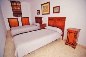 a bedroom with two beds and wooden furniture at Casa rural “Ca Robert” in Callosa de Ensarriá