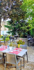 une table et des chaises assises dans une terrasse arborée dans l'établissement Campanile Vichy - Bellerive, à Bellerive-sur-Allier