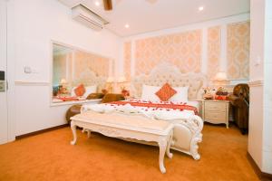 um quarto com uma cama branca e um espelho em King's Hotel Yên Hòa em Hanói