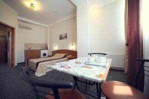 a hotel room with a table and two beds at Flamingo Hotel in Alushta