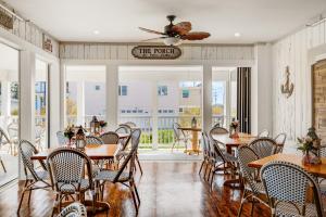 un restaurante con mesas y sillas y un balcón en Surf City Hotel, en Surf City