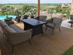 a patio with a table and chairs on a deck at Tatsopus in Kamianets-Podilskyi