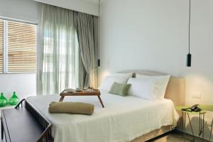 a bedroom with a large bed with a table on it at Domìa Boutique Hotel e Cucina in Mondello