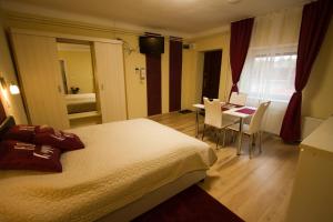 ein Hotelzimmer mit einem Bett, einem Tisch und Stühlen in der Unterkunft Angyal apartman in Cserkeszőlő