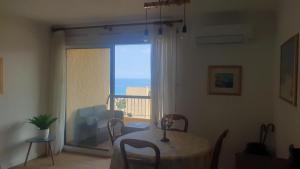 a dining room with a table and a view of the ocean at Bastia Appartement 3 chambres vue mer in Bastia