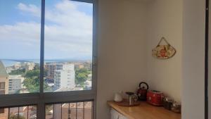 a kitchen with a window view of a city at Bastia Appartement 3 chambres vue mer in Bastia