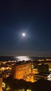 a view of a city at night with a moon at Bastia Appartement 3 chambres vue mer in Bastia