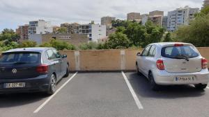 two cars parked in a parking lot in a city at Bastia Appartement 3 chambres vue mer in Bastia