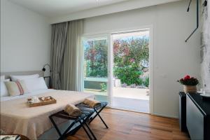 a bedroom with a bed and a large window at Domìa Boutique Hotel e Cucina in Mondello