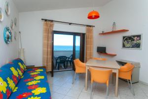 - un salon avec un canapé, une table et des chaises dans l'établissement RS323 - Marcelli, bilocale fronte mare con spiaggia inclusa, à Marcelli