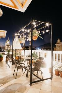 un patio con mesa, sillas y luces en Maison verte - Guest House, en Arequipa