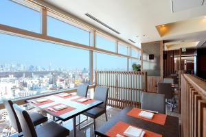 a restaurant with tables and chairs and a large window at Shibuya Excel Hotel Tokyu in Tokyo