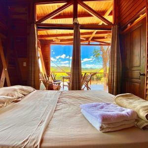 ein großes Bett in einem Zimmer mit einem großen Fenster in der Unterkunft Hoja Azul in Hojancha