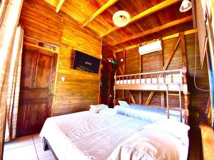 een slaapkamer met een bed in een houten hut bij Hoja Azul in Hojancha