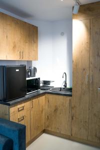 a kitchen with wooden cabinets and a microwave at Good Night in Warsaw