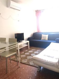 sala de estar con sofá azul y mesa en Apartamento en el centro de Malaga, en Málaga